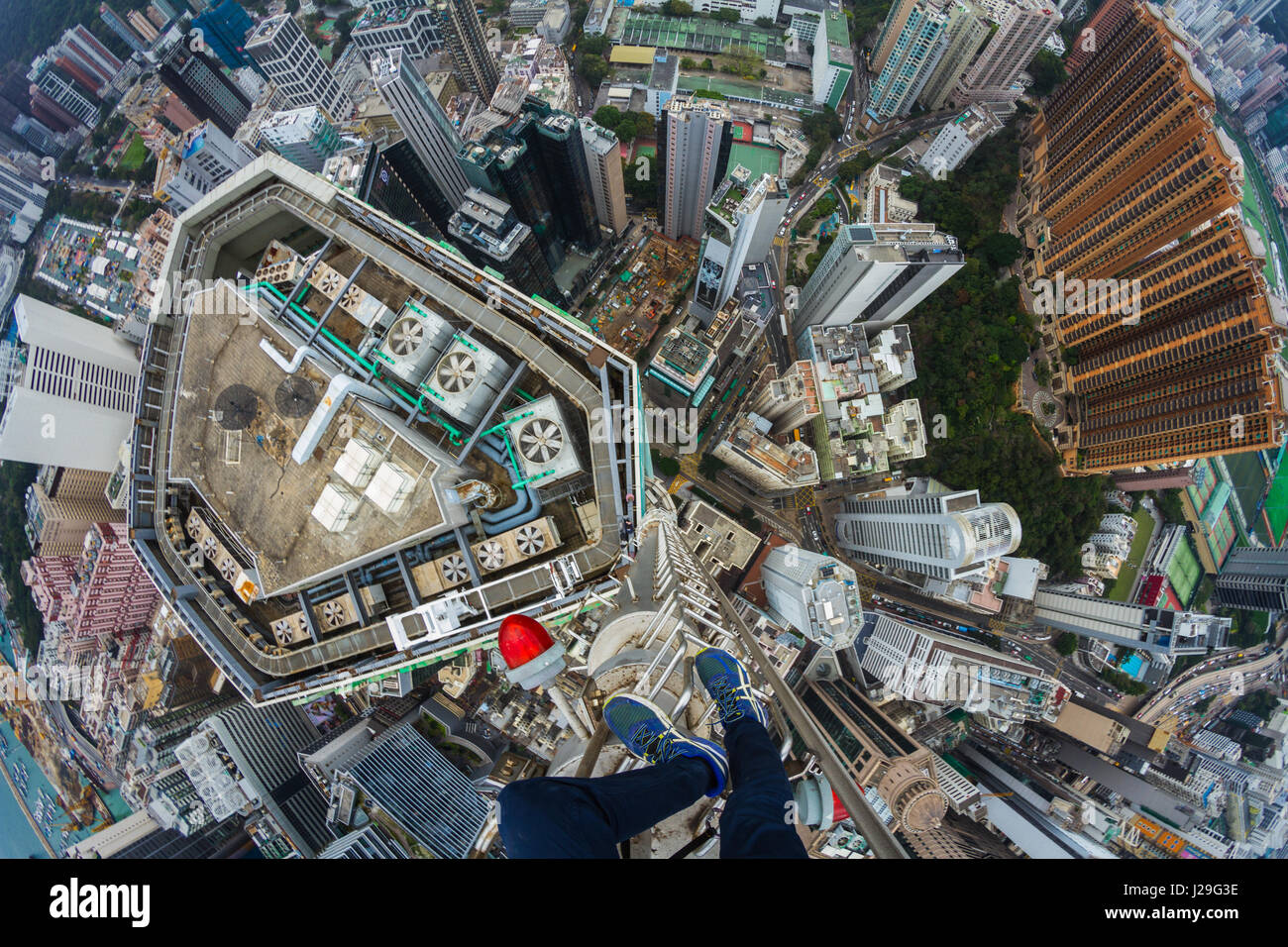 Denis Rooftopper Krasnov guarda verso il basso oltre la città. MIND-blowing foto di un team di brivido conquistando tetti oltre otto cento metri di altitudine rendono impossibile di non guardare in basso. Questi vertigo indurre le immagini sono state prese quando il gruppo di temerari si è recato in visita a Hong Kong in un viaggio di esplorazione. Le riprese mostrano il gruppo appeso fuori del lato di edifici, affacciato sul traffico frenetico al di sotto e il bilanciamento nella parte superiore di una colonna di metallo senza sicurezza di marcia. Il fiato immagini sono state scattate dal fotografo russo Denis Krasnov (20). Quando lui per primo ha avuto l idea di viaggiare a Hong Kong, Denis Foto Stock