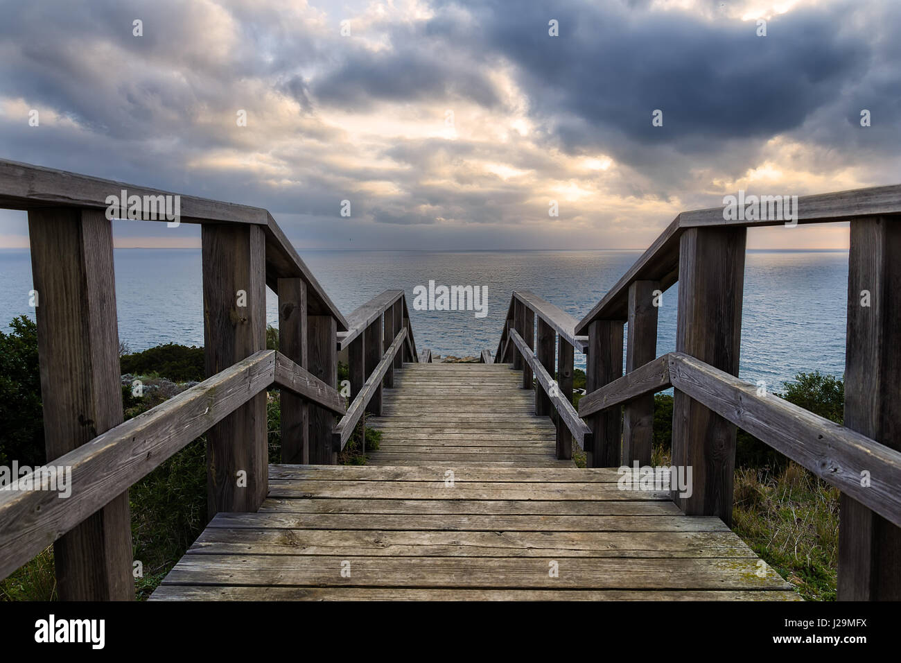 Le scale che conducono in basso verso il litorale al tramonto. Cadiz Costa, Spagna. Foto Stock