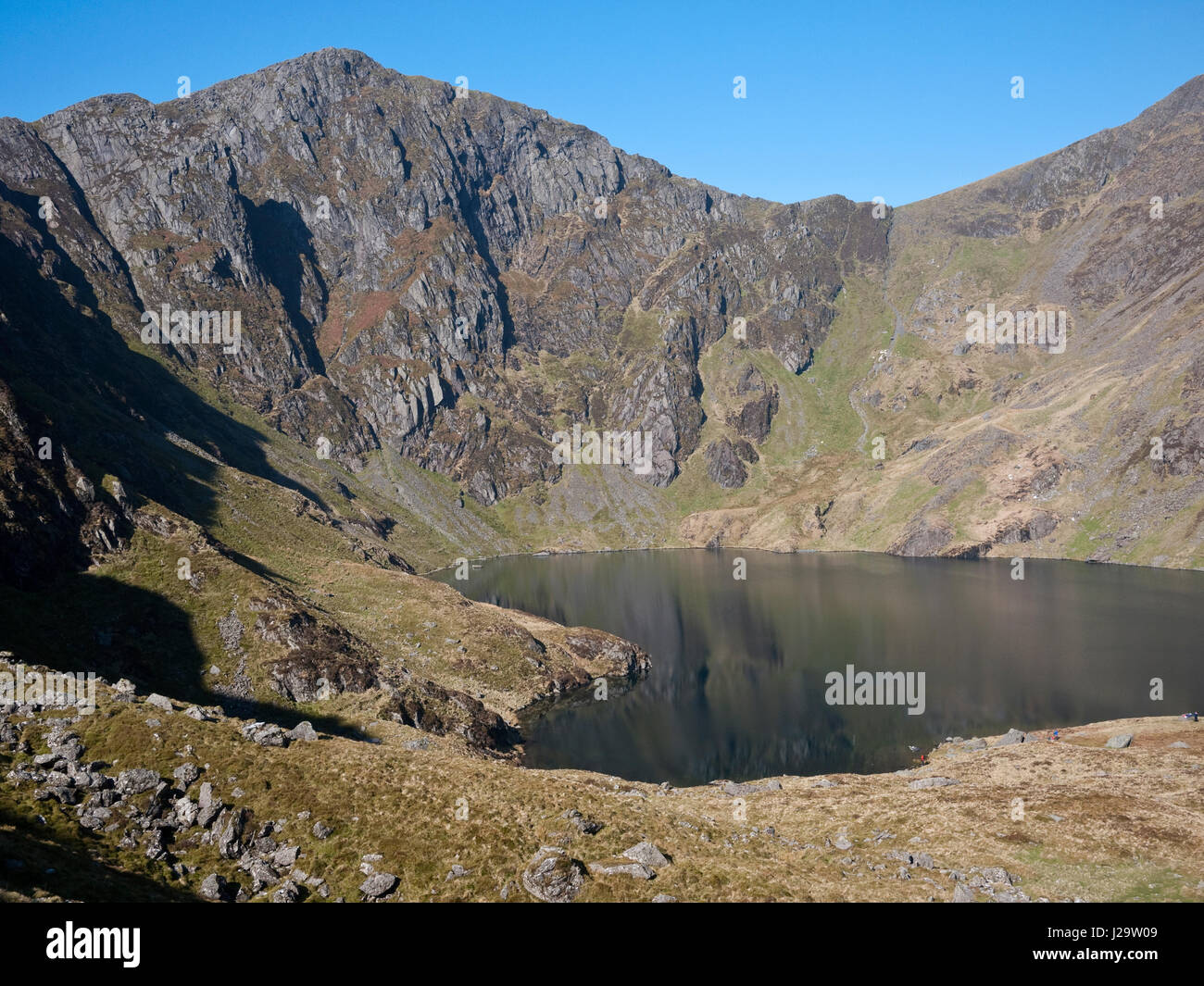 Le balze di Craig Cau torre sopra il lago di Llyn Cau in Cwm Cau, al di sotto del vertice di Cadair Idris, nel Parco Nazionale di Snowdonia, il Galles del Nord Foto Stock