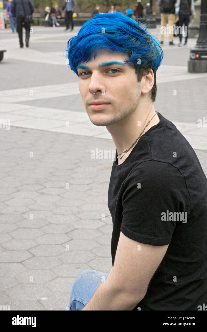 Uno studente di college con il blu e il verde per i capelli e il blu e il verde delle sopracciglia. In Washington Square Park a Manhattan, New York City. Foto Stock