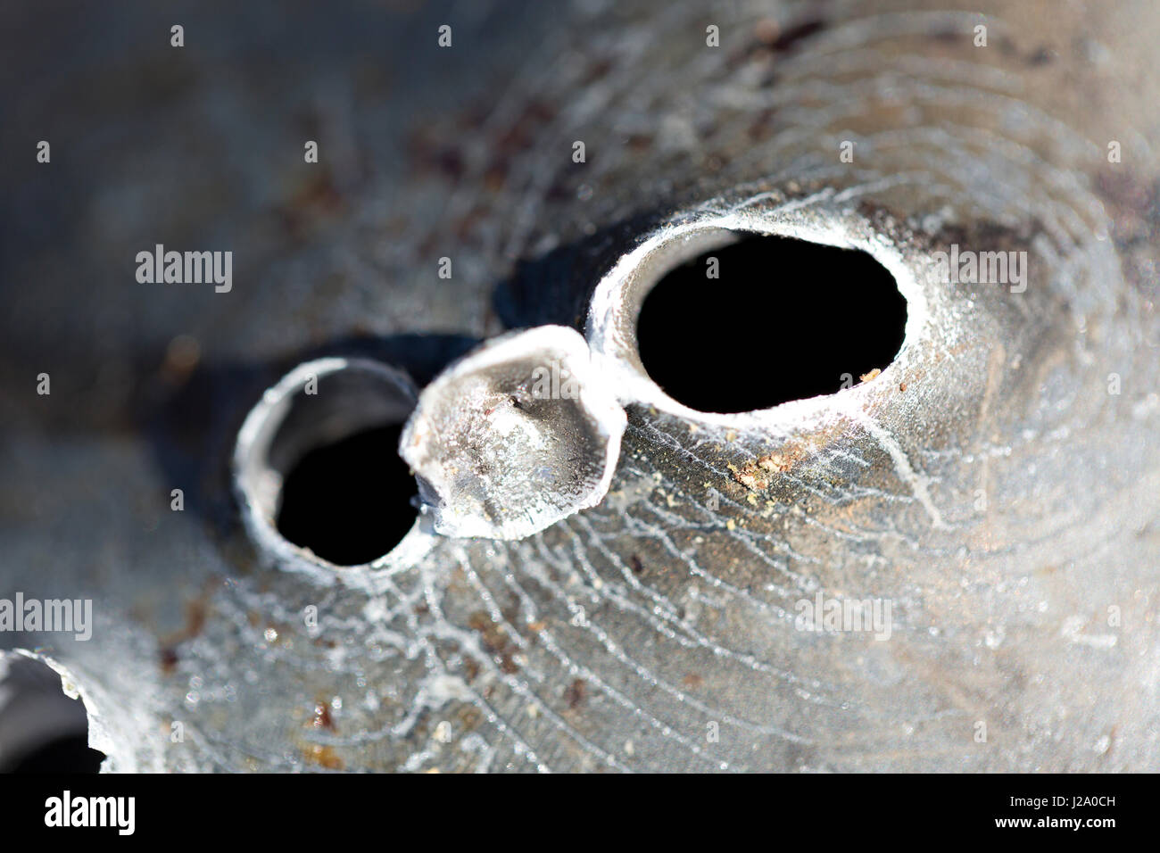 Macro shot di fori di proiettile dopo un tiro al bersaglio in una vaschetta di alluminio. Foto Stock