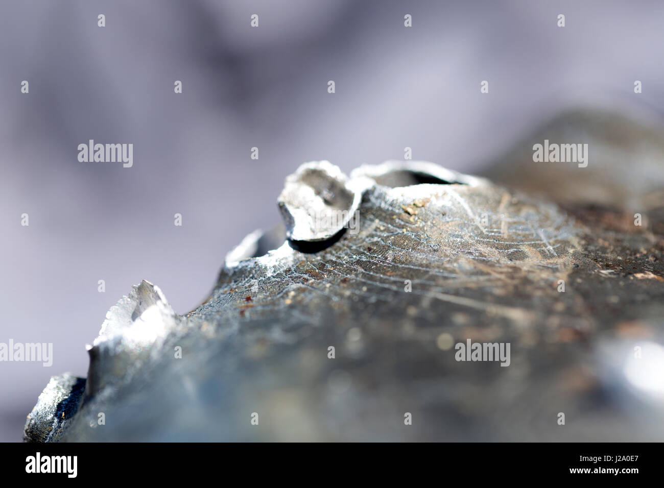 Macro shot di fori di proiettile dopo un tiro al bersaglio in una vaschetta di alluminio. Foto Stock
