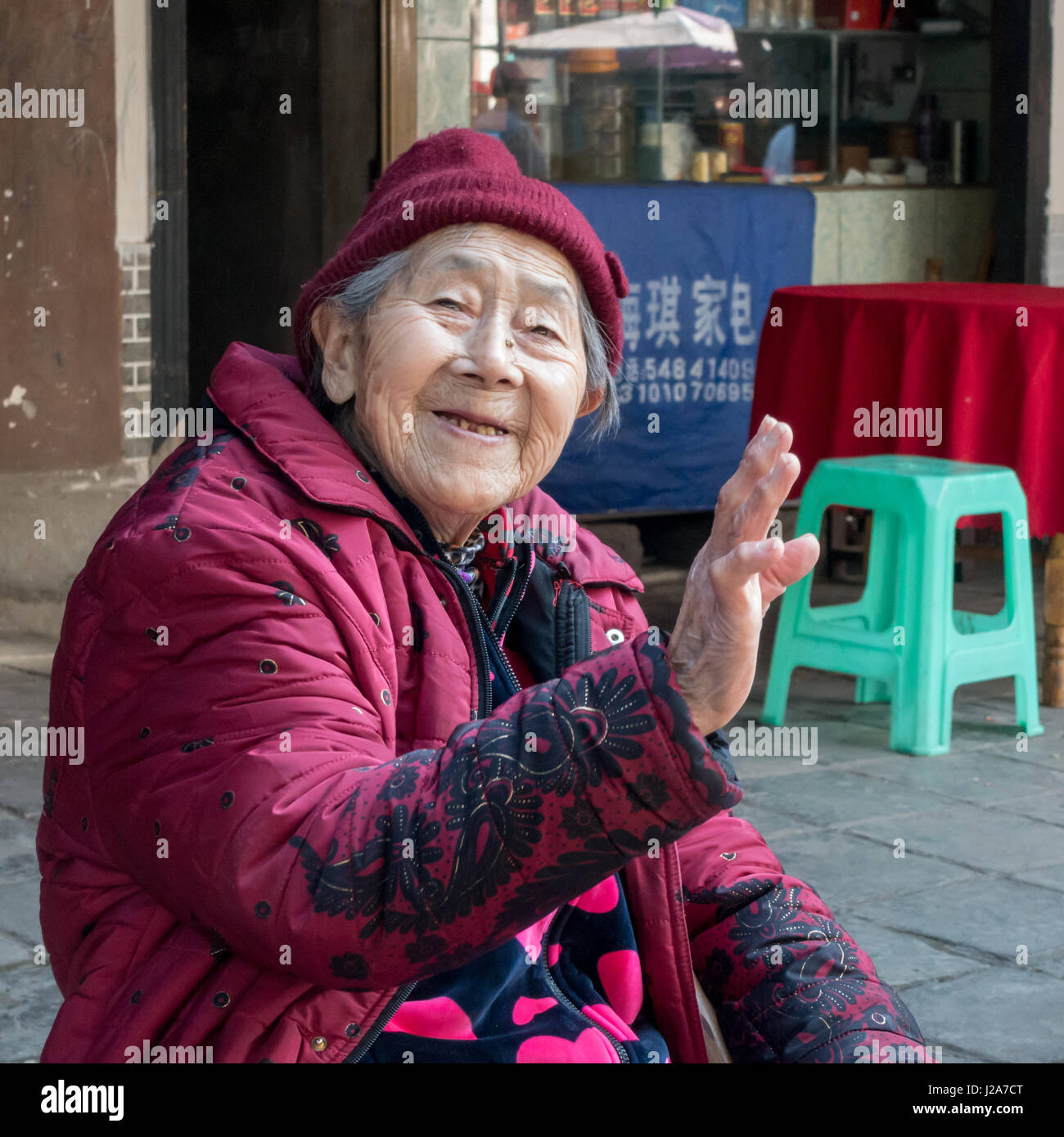 Lo stile di vita locale in Cina: vecchia donna cinese sventolare e sorridente, Cina Foto Stock