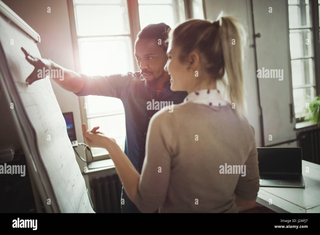 Collaboratori a lavorare insieme come una squadra e discutere le idee in ufficio Foto Stock