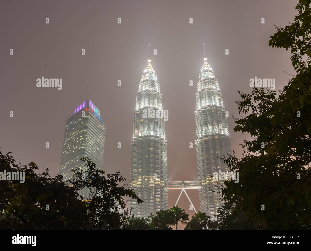 Vista delle Torri Gemelle Petronas su un vago di notte. La nebulosità è causato dalla foresta indonesiana incendi. Kuala Lumpur, Malesia. Foto Stock