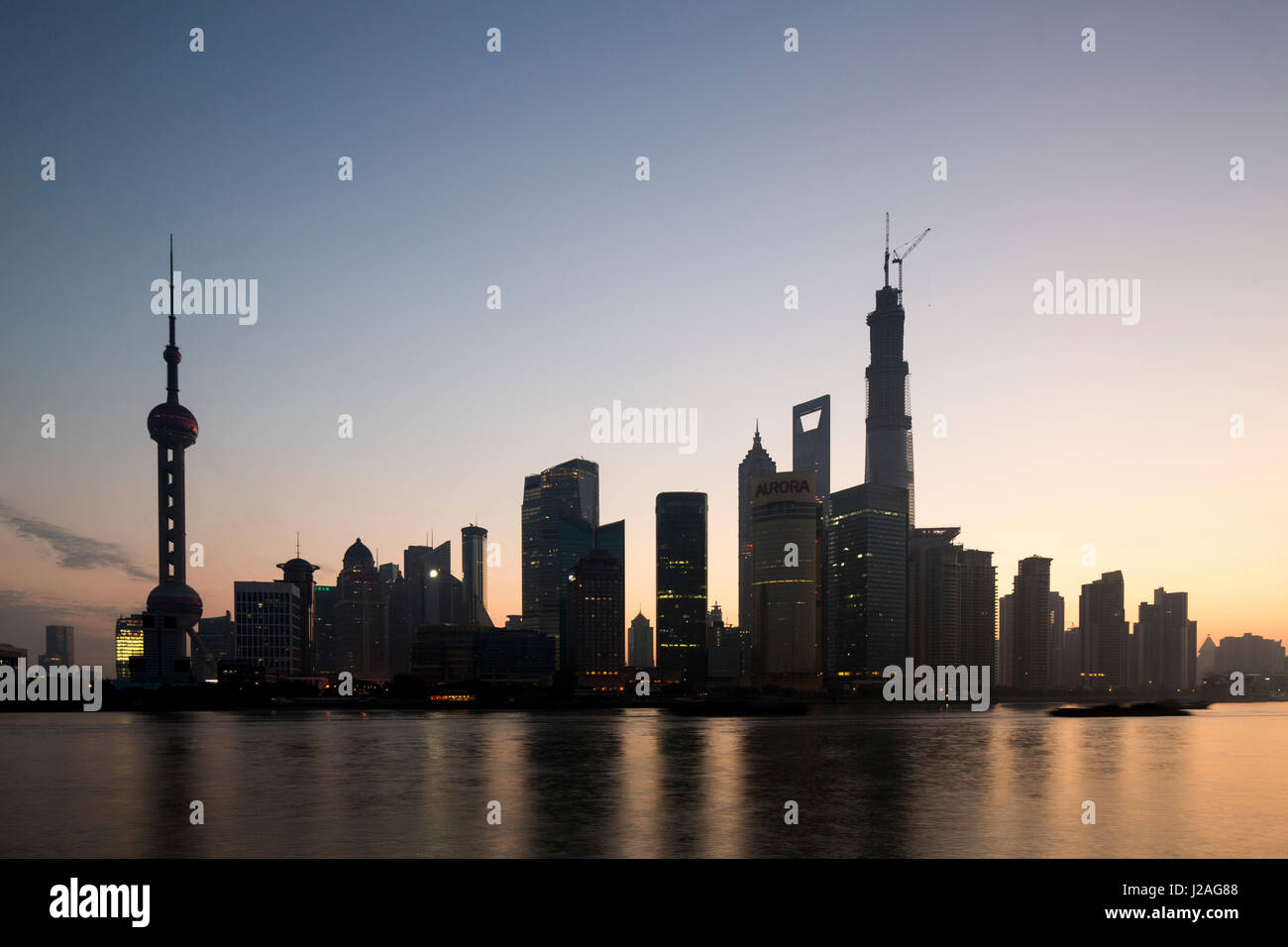 Cina, Shanghai, bagliore del crepuscolo dietro torreggiante skyline del quartiere Pudong lungo il fiume Huangpu sulla mattina di autunno Foto Stock