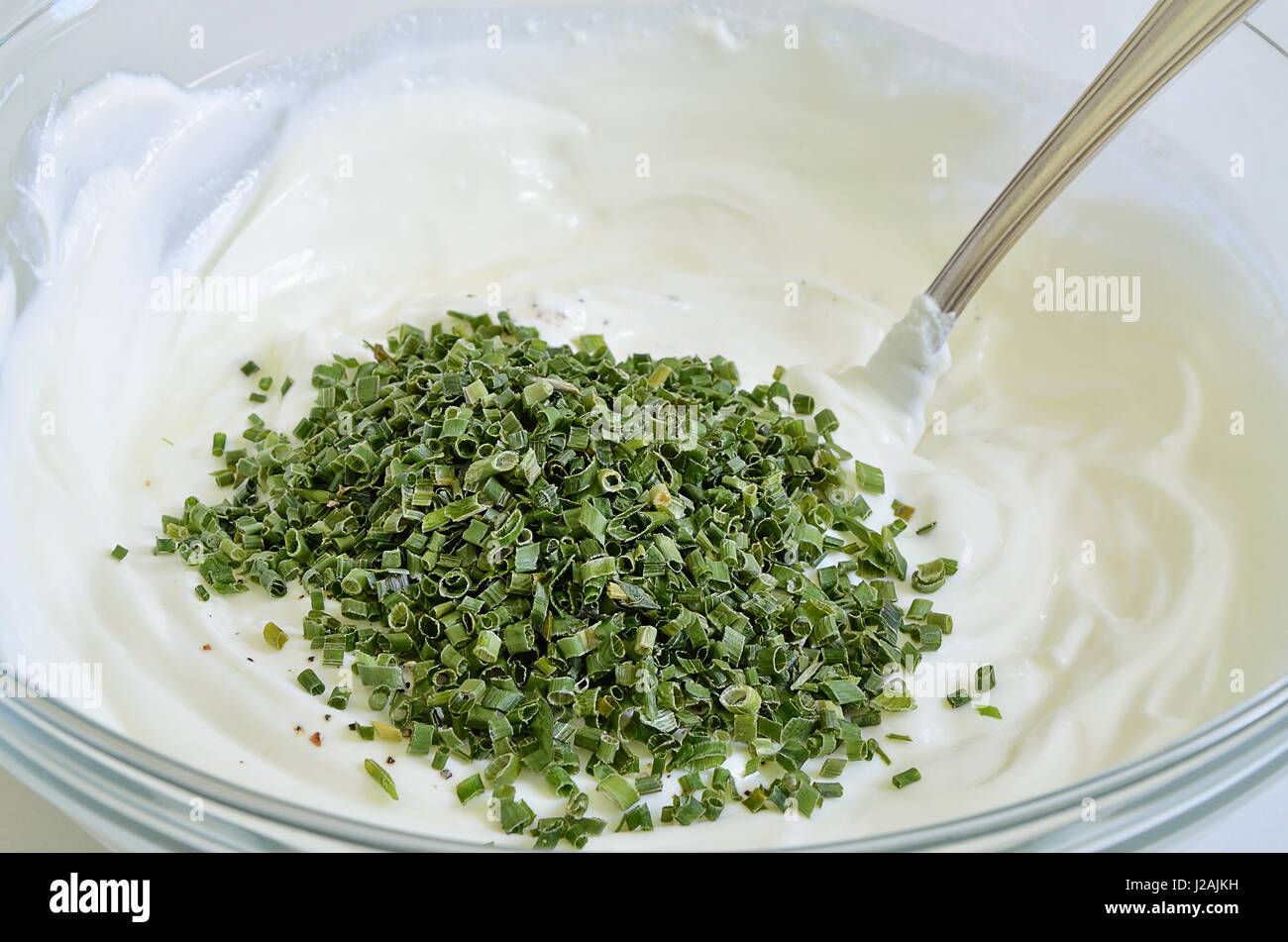 Formaggio con erba cipollina in una ciotola, close up, macro, frame completo Foto Stock