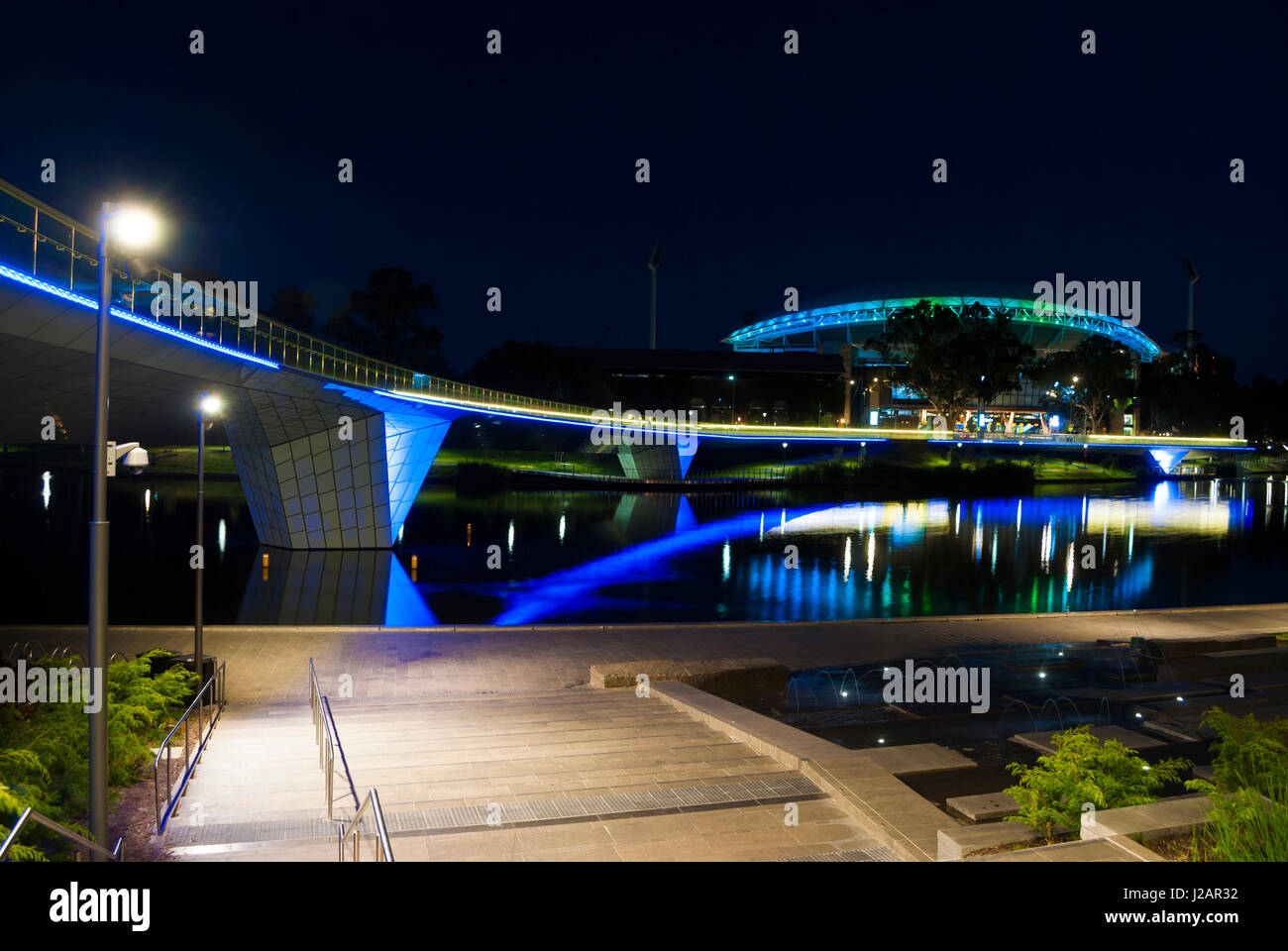 Adelaide, South Australia, Australia - 1 Gennaio 2015: tempo di notte le luci sulla Adelaide Oval piedi ponte sopra il Fiume Torrens e l'Adelaide ovuli Foto Stock