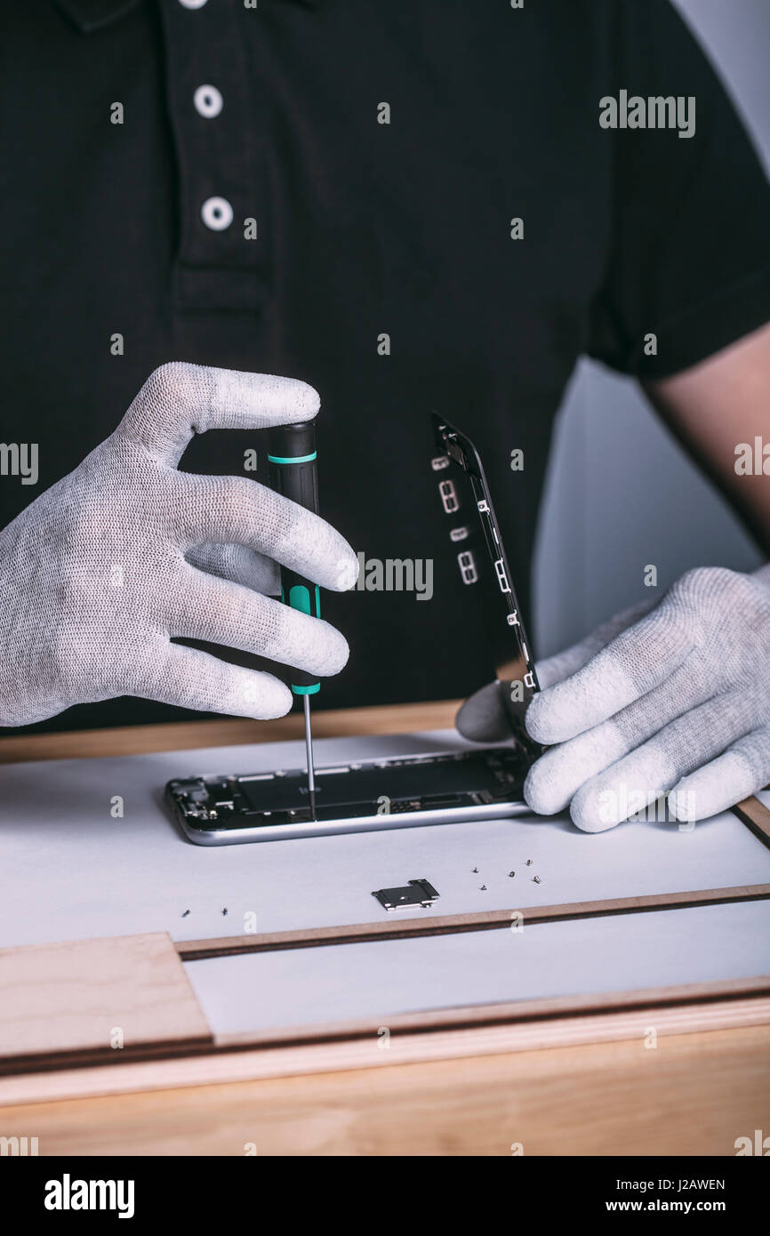 Sezione mediana del tecnico di riparazione cellulare al negozio di elettronica Foto Stock