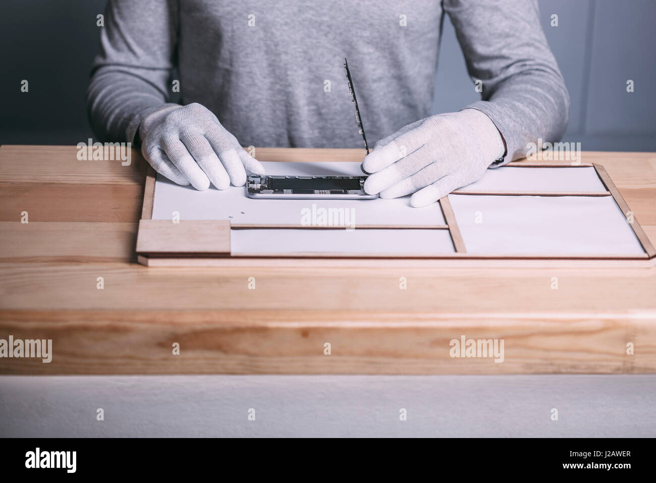 Sezione mediana del tecnico maschio apertura smart phone al negozio di elettronica Foto Stock