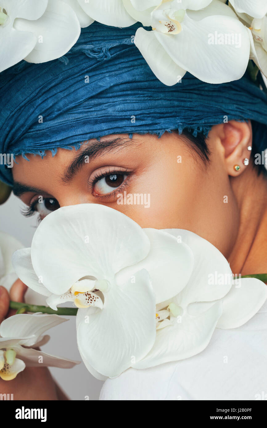 Ritratto di donna nascosto dietro fresche le orchidee bianche Foto Stock
