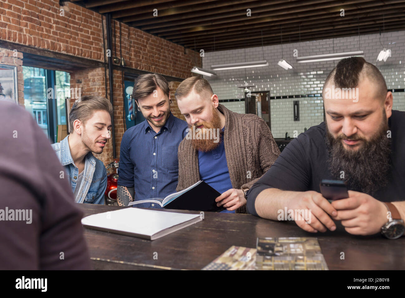 Felice parrucchieri maschio al banco bar in un barbiere Foto Stock Felice parrucchieri maschio al banco bar in un barbiere Foto Stock
