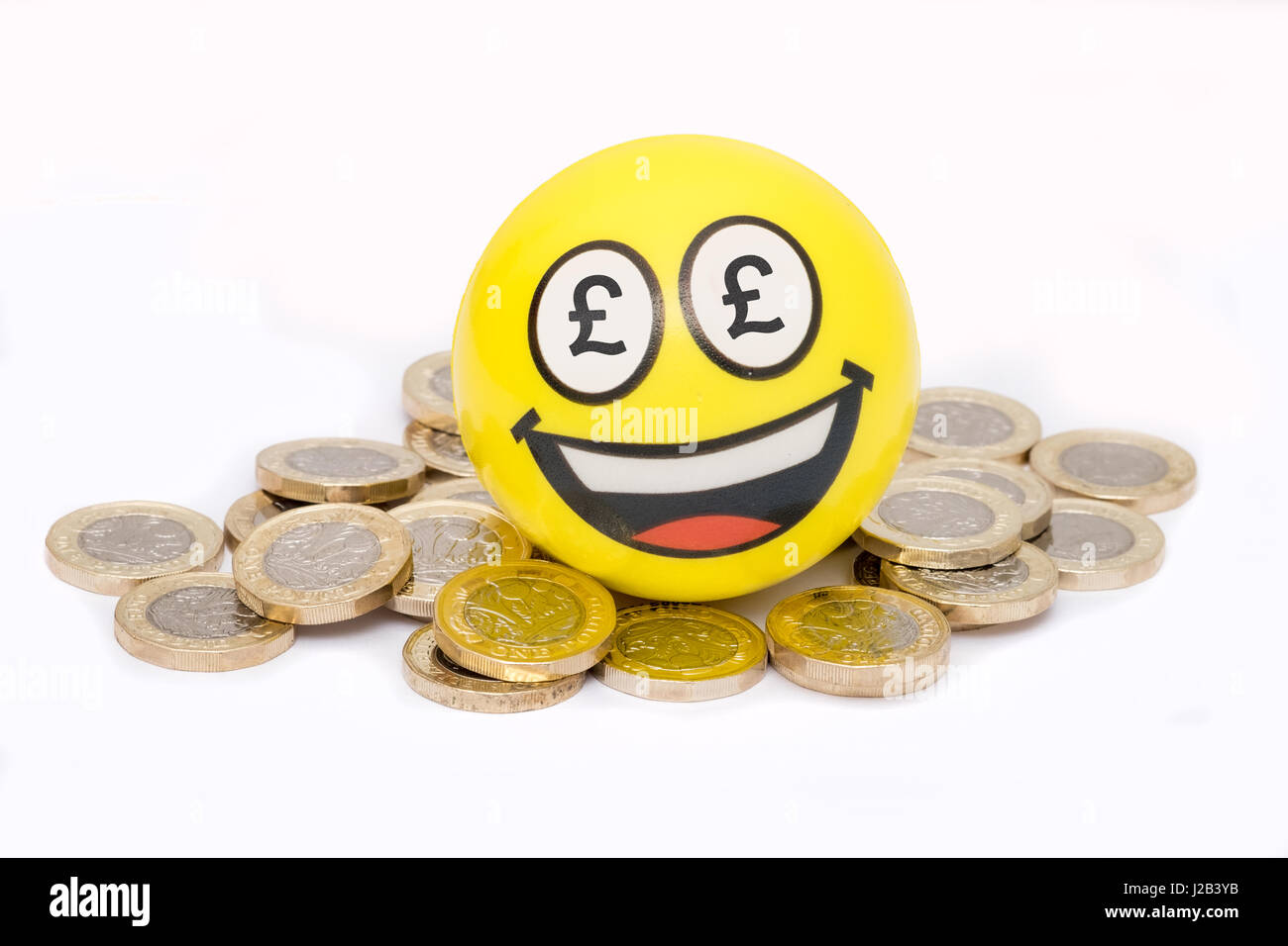 Happpy gli Emoji sulla pila di British pound monete Foto Stock