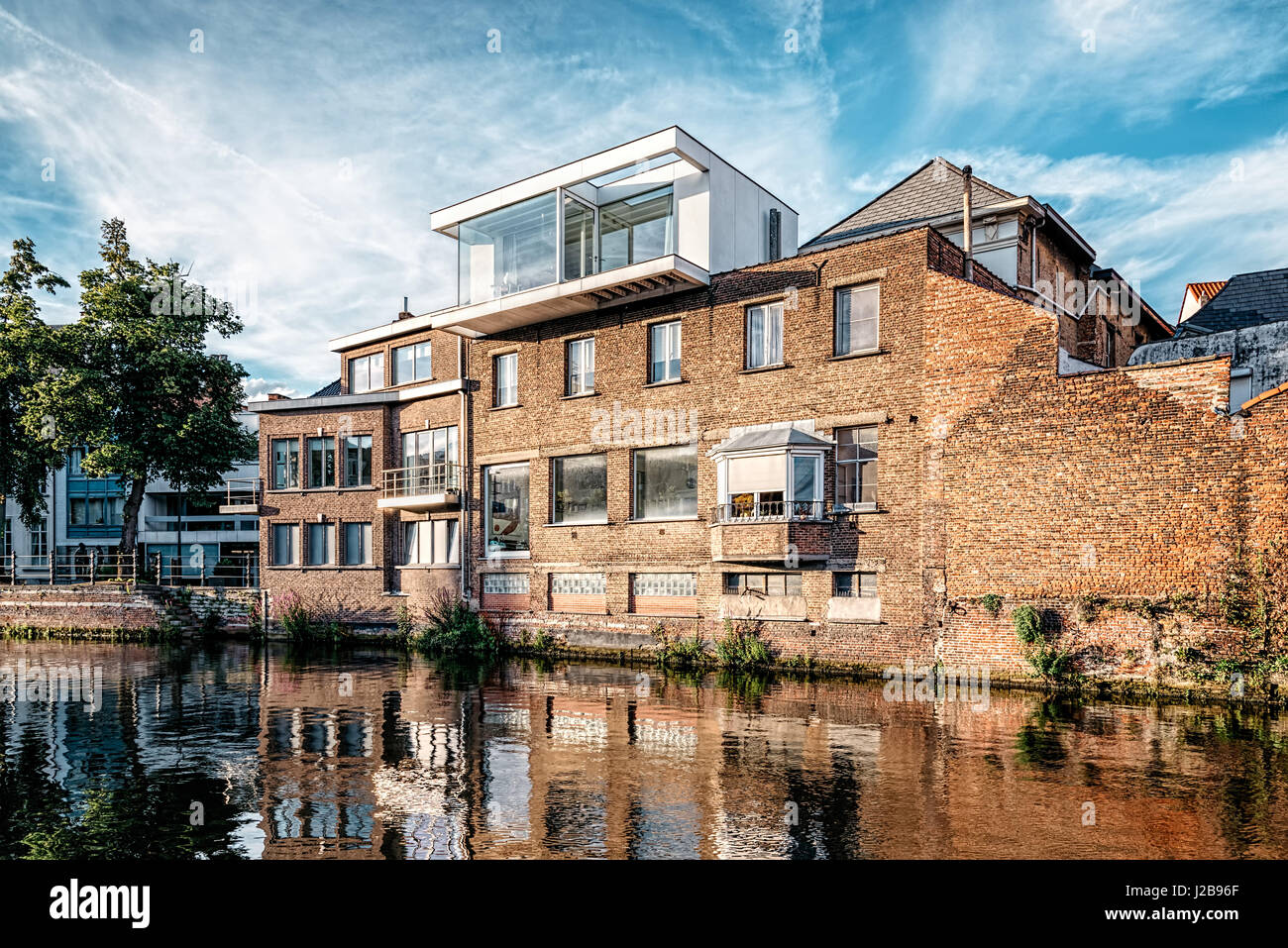 Mechelen, Belgio - 29 Luglio 2016: Cityscape di Mechelen con vecchie costruzioni risanate sul canale. Estensione di un vecchio edificio con moderni archi Foto Stock