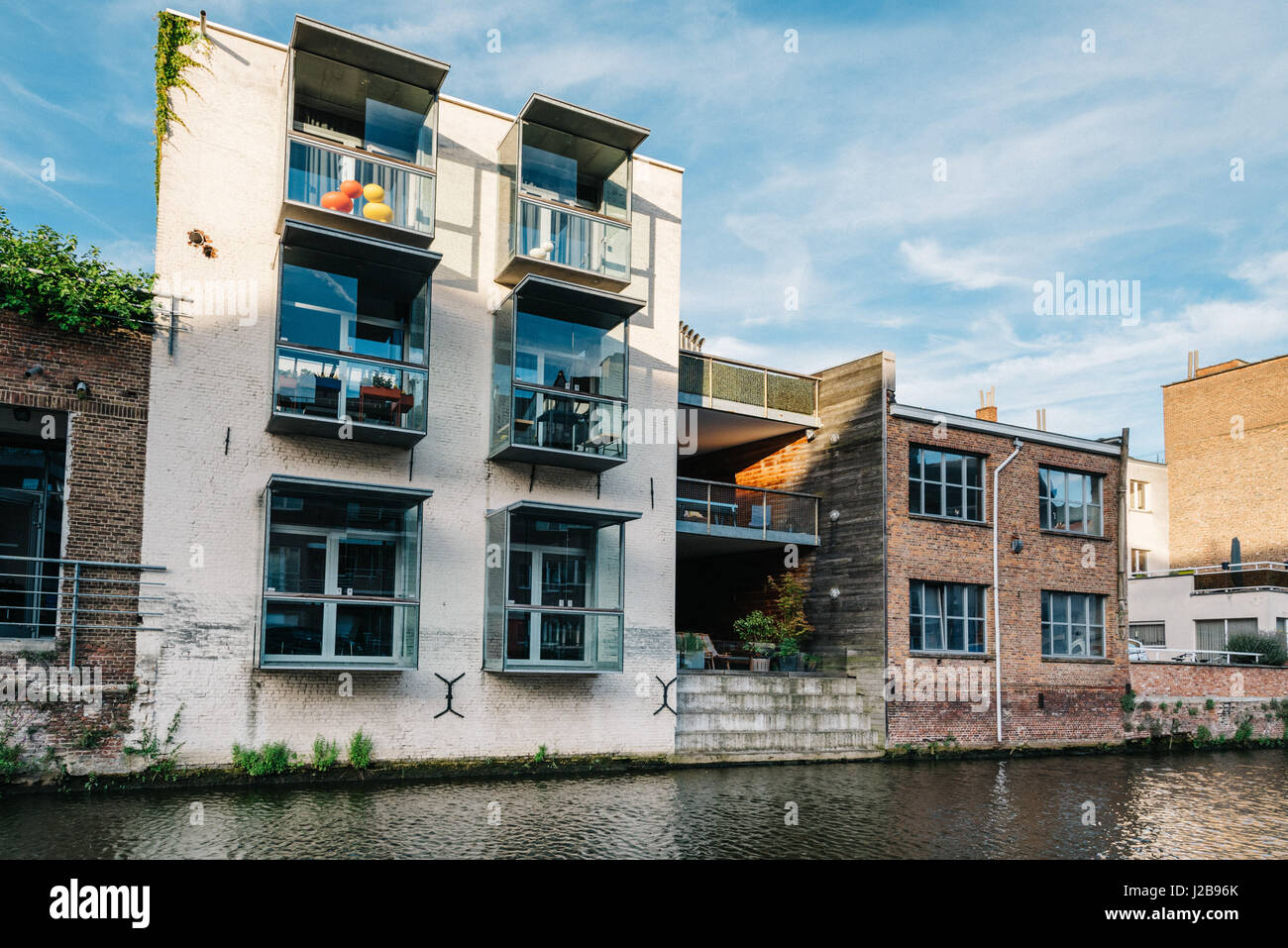 Mechelen, Belgio - 29 Luglio 2016: Cityscape di Mechelen con vecchie costruzioni risanate sul canale. Estensione di un vecchio edificio con moderni archi Foto Stock