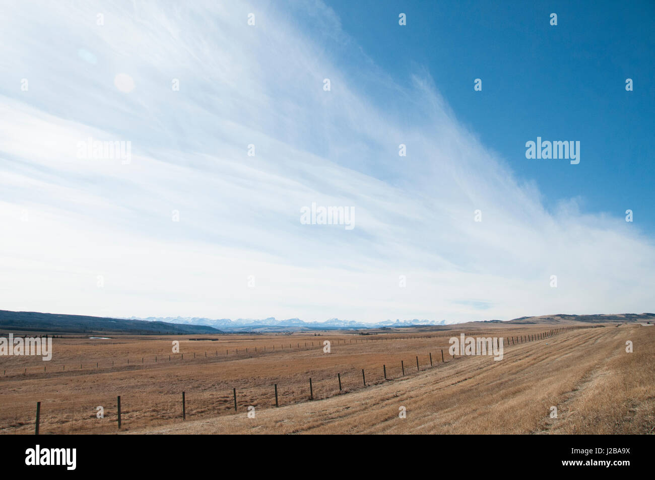 Le montagne rocciose sono visibili in lontananza da questo prairie ranch nel Canada occidentale. Foto Stock