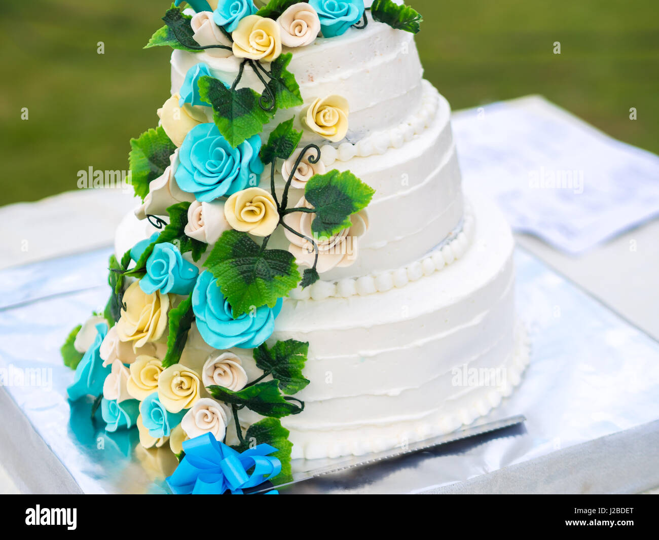 Bella torta di nozze con blu e giallo rose Foto Stock