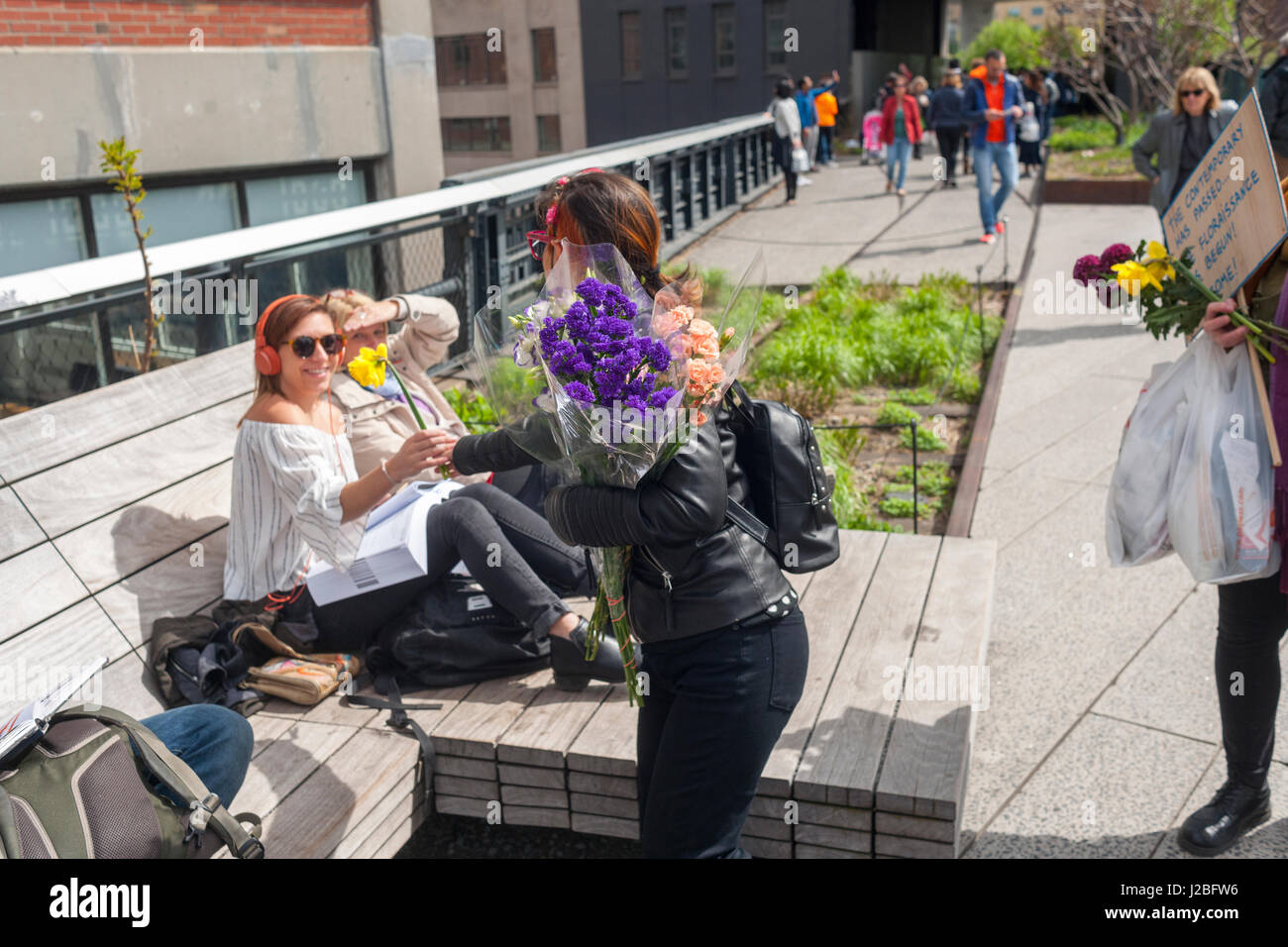 Regista brasiliano Caru Alves, Centro assiste l'artista brasiliano, André Feliciano noto come "arte giardiniere a piedi giù per la linea alta Park di New York di Domenica, 23 aprile 2017 la distribuzione di palloncini e fiori a passante nelle sue prestazioni pezzo di arte, il Floraissance parade. Il Floraissance è un'arte movimento creato da Feliciano basata sull'idea che l'attuale non è in grado di descrivere la tecnica più e abbiamo arte in movimento nella fase successiva, crescendo come i fiori nel Floraissance. (© Richard B. Levine) Foto Stock