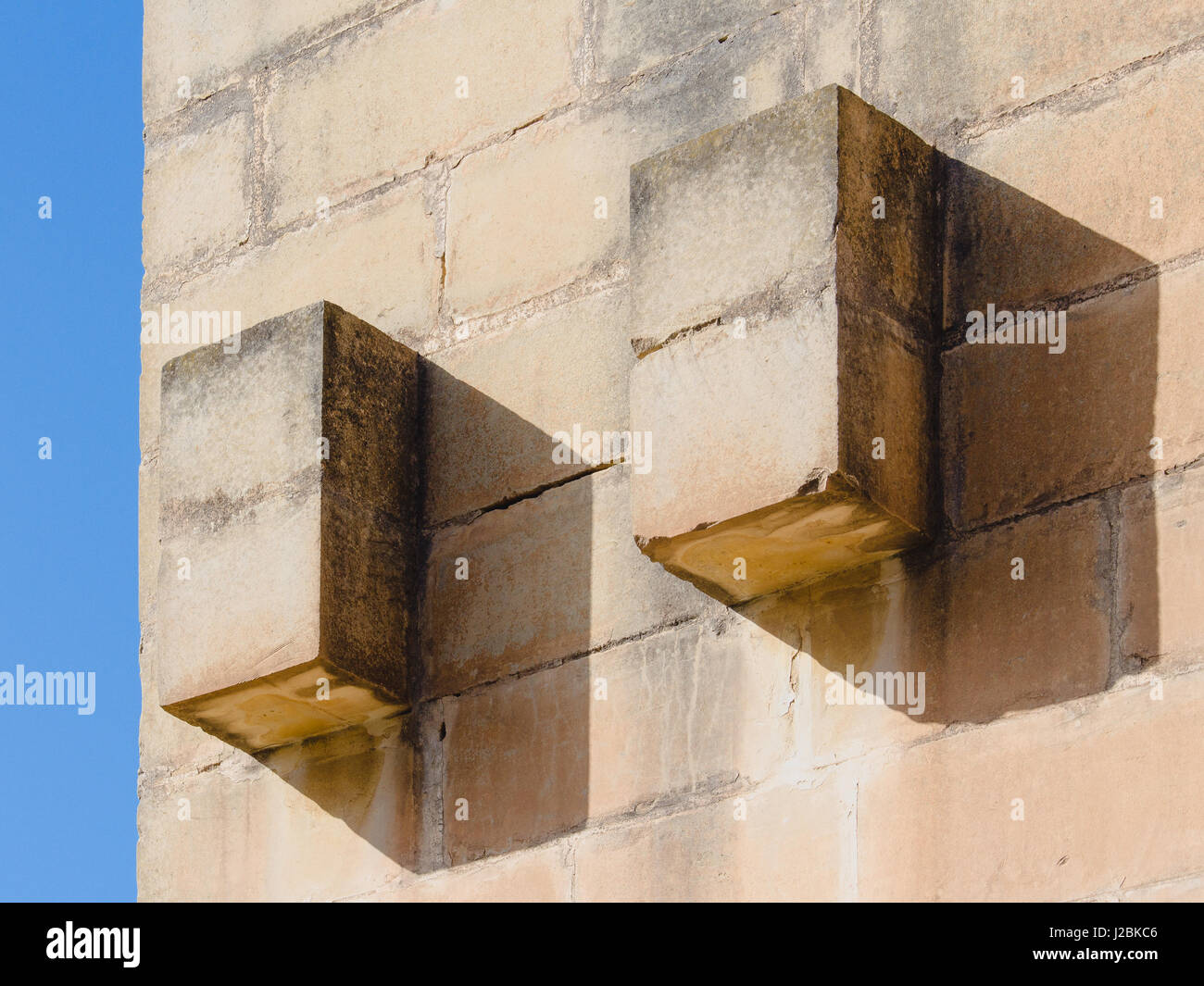 Dettaglio della muratura semplice decorazione in Malta (Maltese) in ambienti con luce diurna definito chiaramente le ombre e uno sfondo di cielo blu. Foto Stock