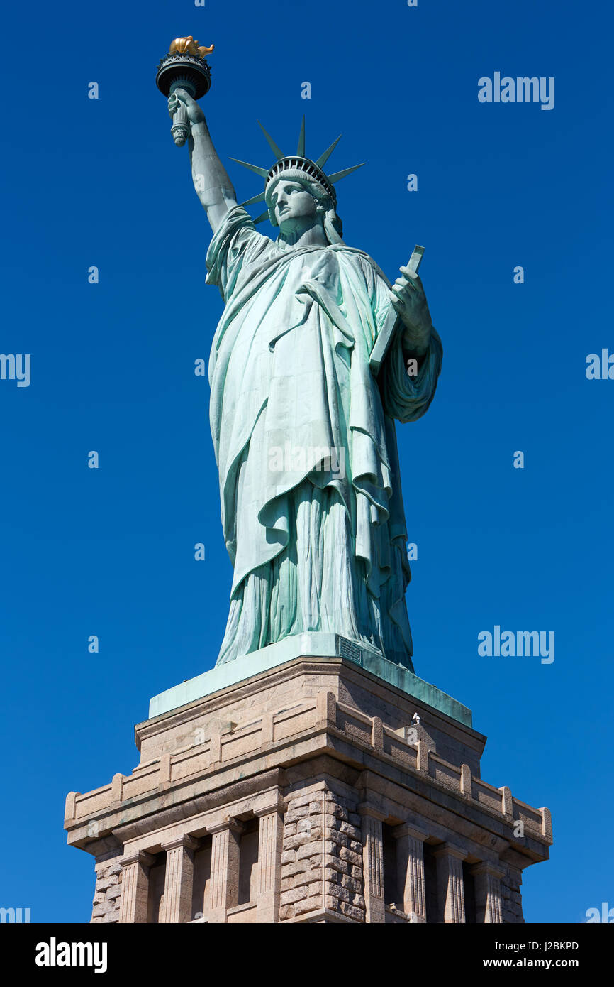 La Statua della Libertà e il piedistallo su chiaro cielo blu scuro in una giornata di sole Foto Stock