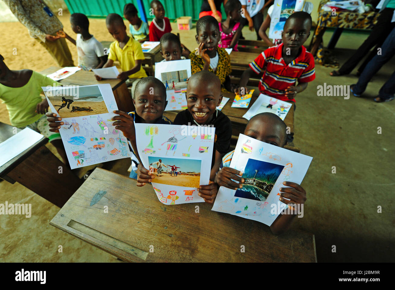 Costa d'Avorio, Abidjan, bambini mostrando i loro disegni durante l'arte in tutti noi attività (MR) Foto Stock