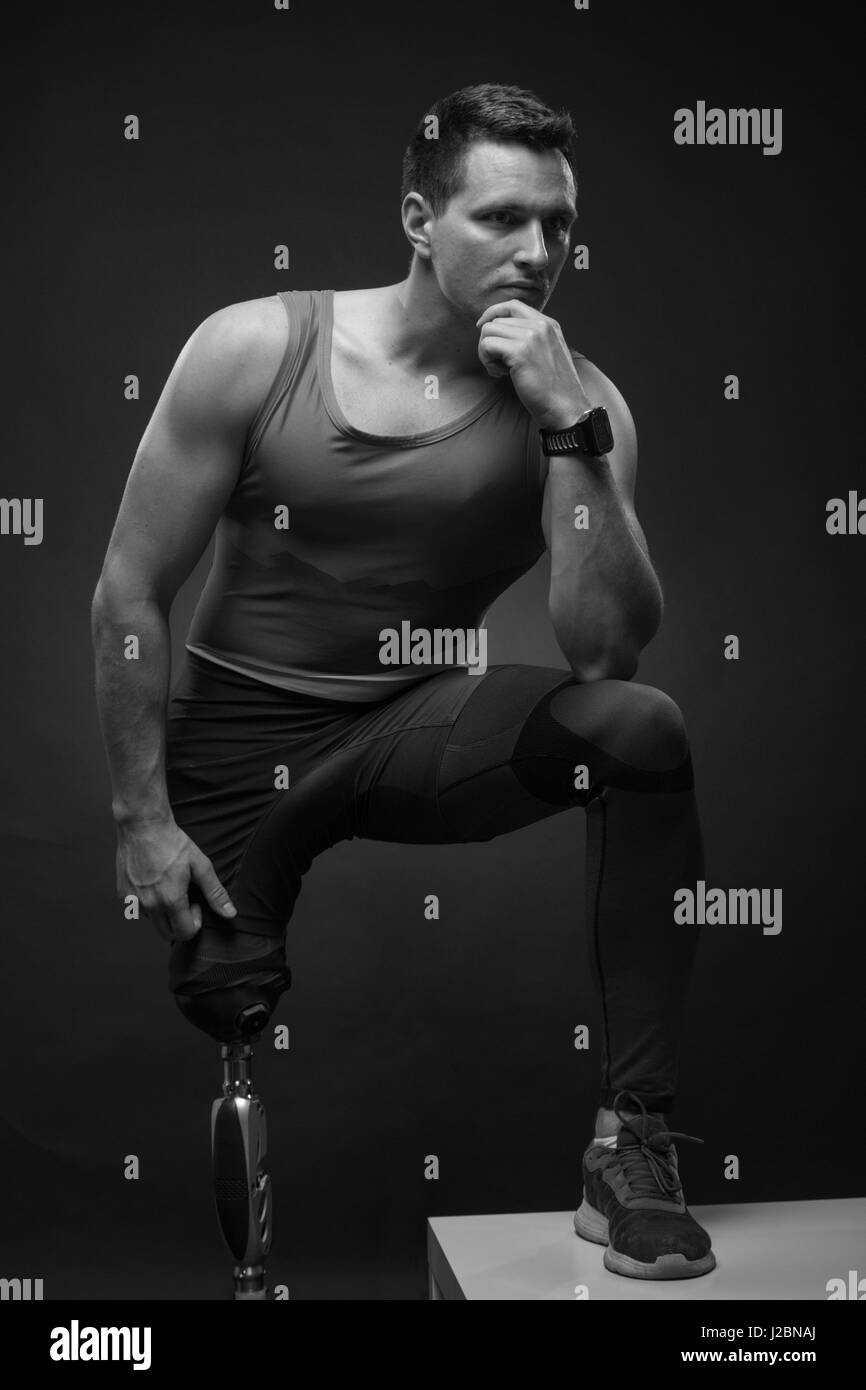Un giovane uomo adulto disabili, atleta atleta in posa, una gamba protesico, in piedi, in bianco e nero Foto Stock