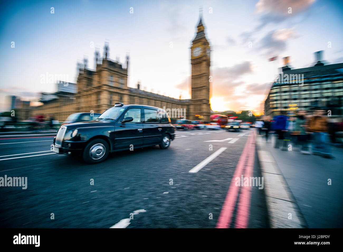 Londra - Ottobre 4, 2016: Nero Londra unità cabina passato il Big Ben e il Parlamento in una sfocatura di movimento sul Westminster Bridge. Foto Stock