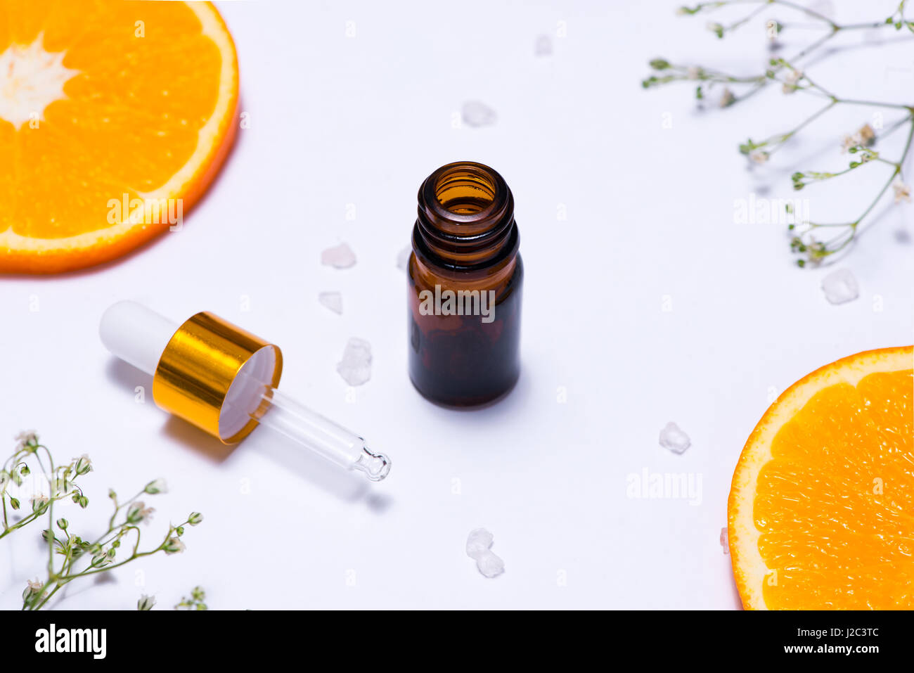 Il Branding mock-up. Olio essenziale naturale, bottiglia di cosmetici contenitori con fettine di arancia. Foto Stock