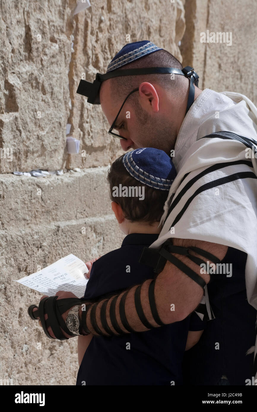 Ebreo ortodosso padre e figlio offrire preghiere al Sacro Muro occidentale del Monte del Tempio a Gerusalemme vecchia. Foto Stock