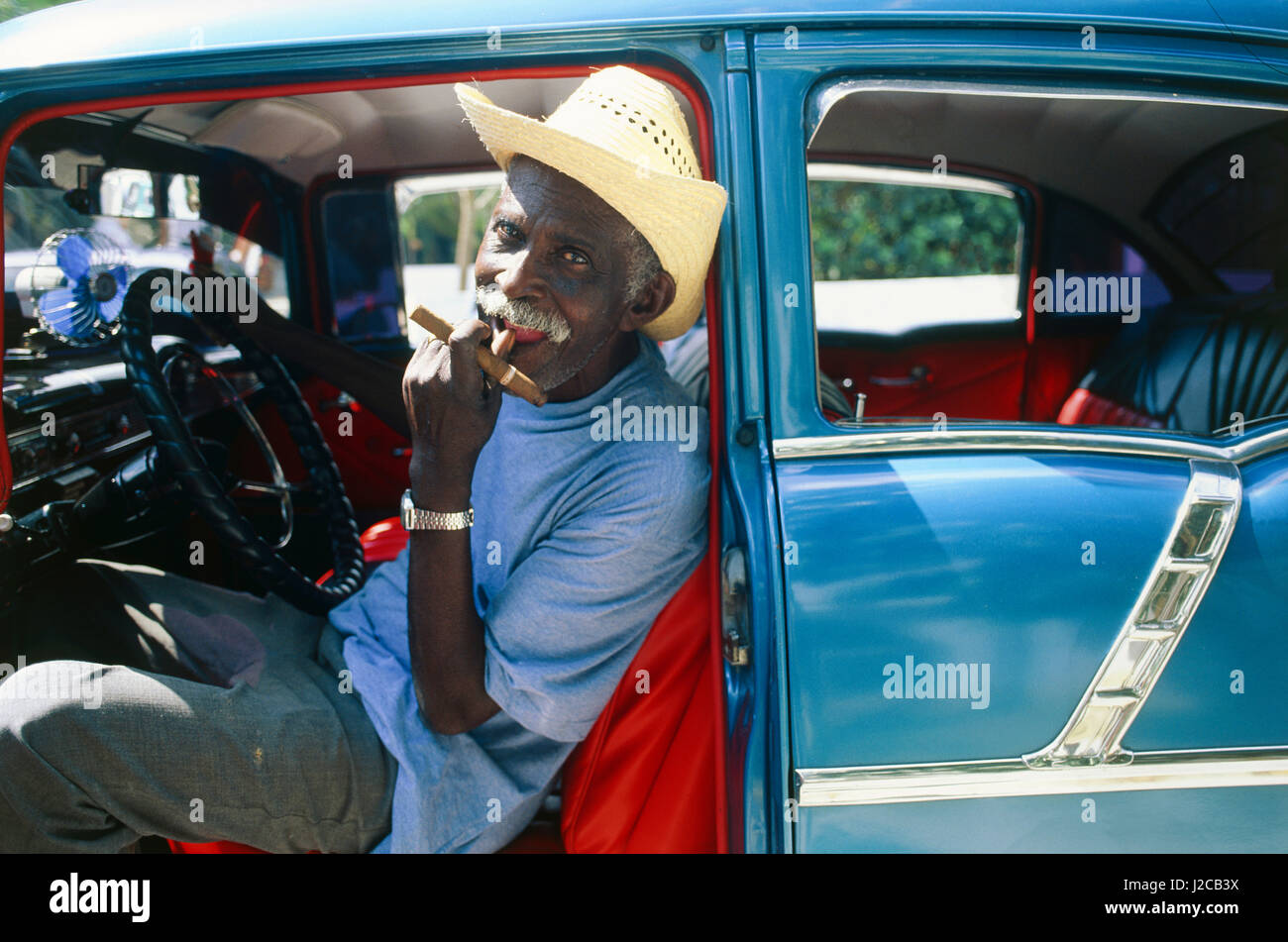 Uomo con sigaro in Classic American car, Cuba Foto Stock