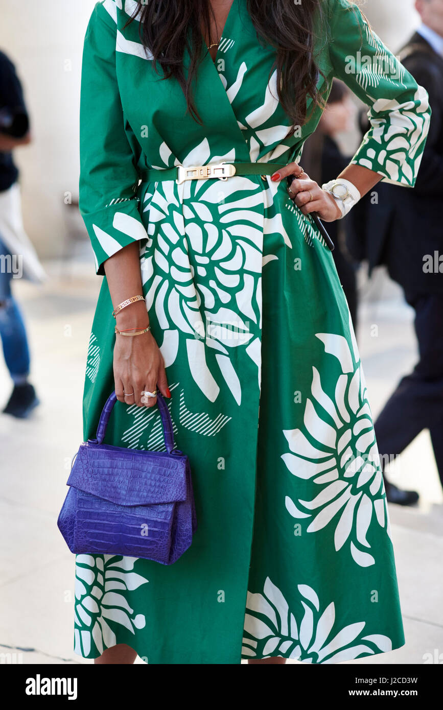La donna in verde wrap-over abito con sacchetto viola, raccolto verticale Foto Stock