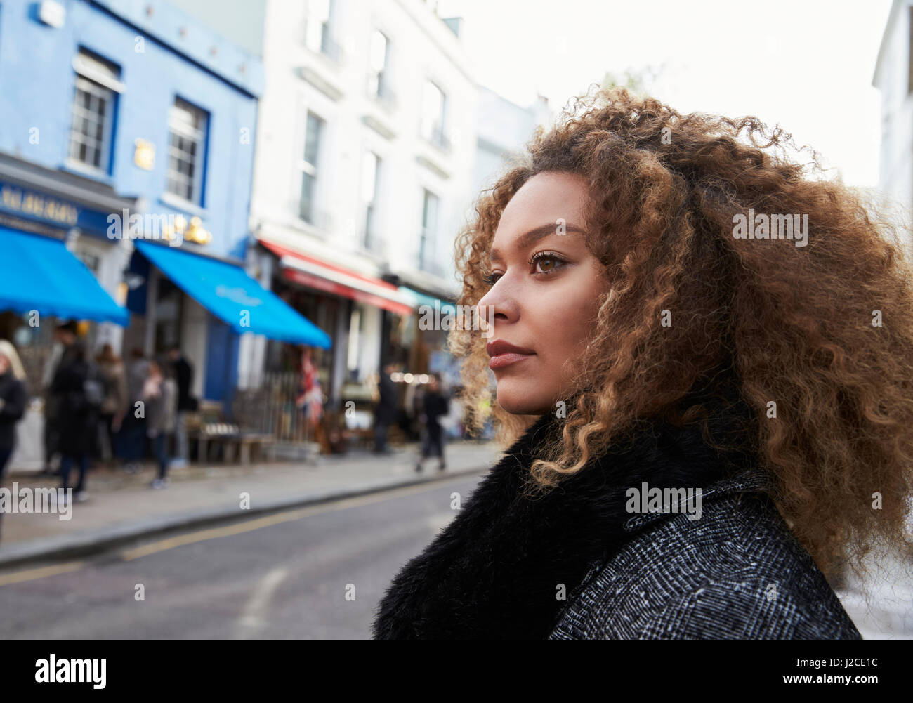 Elegante giovane donna camminando lungo la strada trafficata Foto Stock