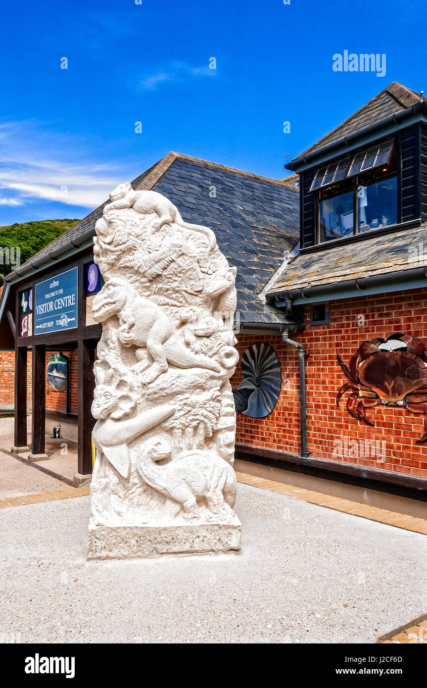 I sei piedi di altezza primordiale scultura realizzata da pietra di Portland che ritraggono creature preistoriche che si trova al di fuori del centro visitatori Lulworth Cove Foto Stock