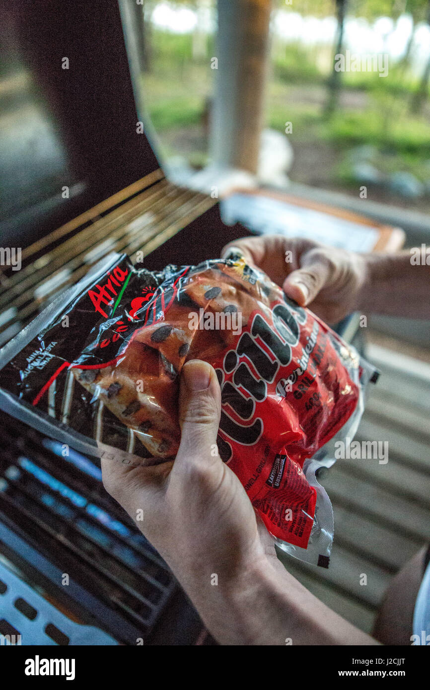 Finlandia, dieci giorni vivono nel Mökki, su un'isola, solo può essere raggiunta in barca a remi. Linnansaari National Park, barbecue salsicce in mano Foto Stock