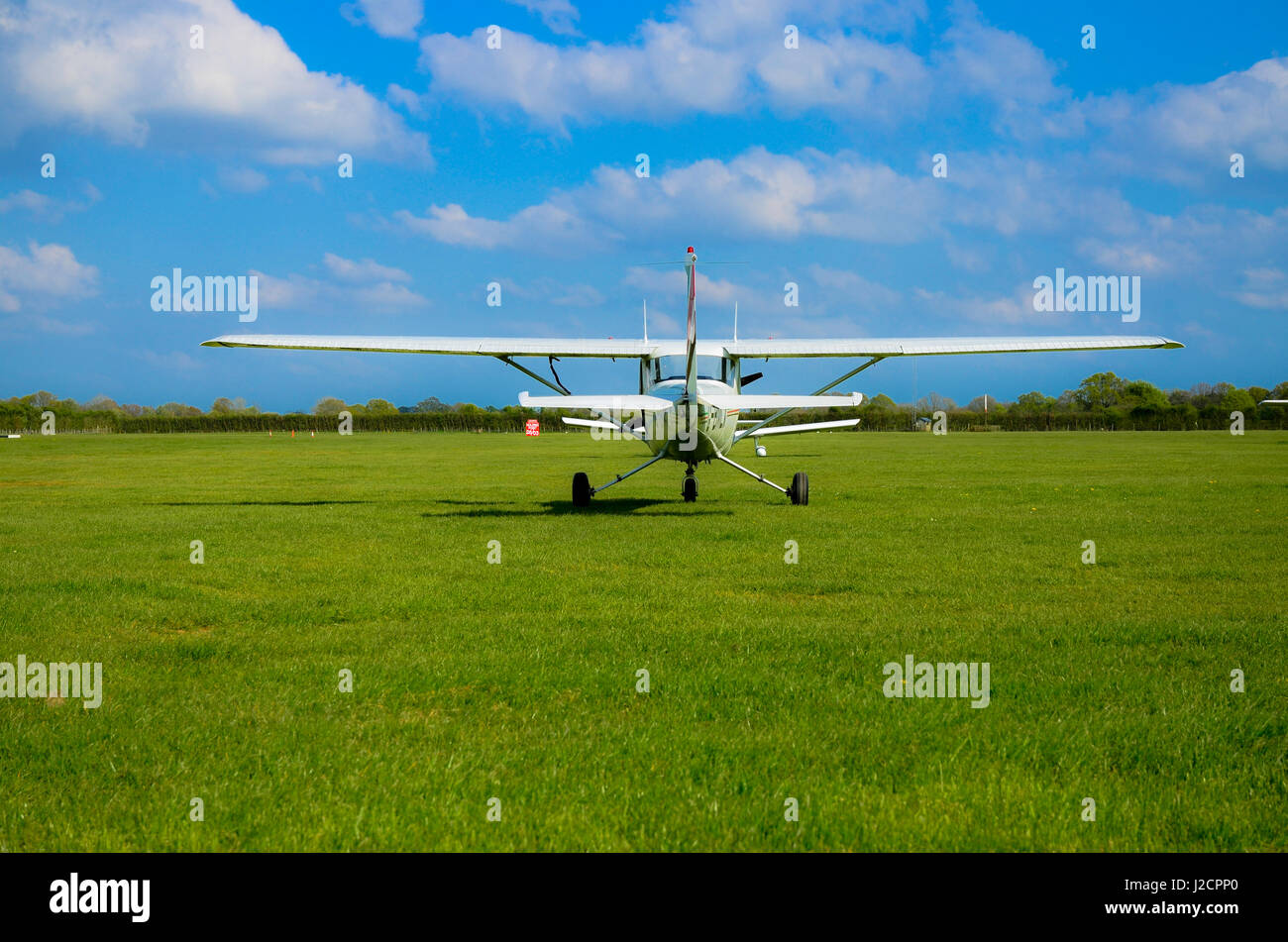 Un piccolo velivolo si prepara a decollare in un campo di aviazione di erba in bella estate meteo Foto Stock