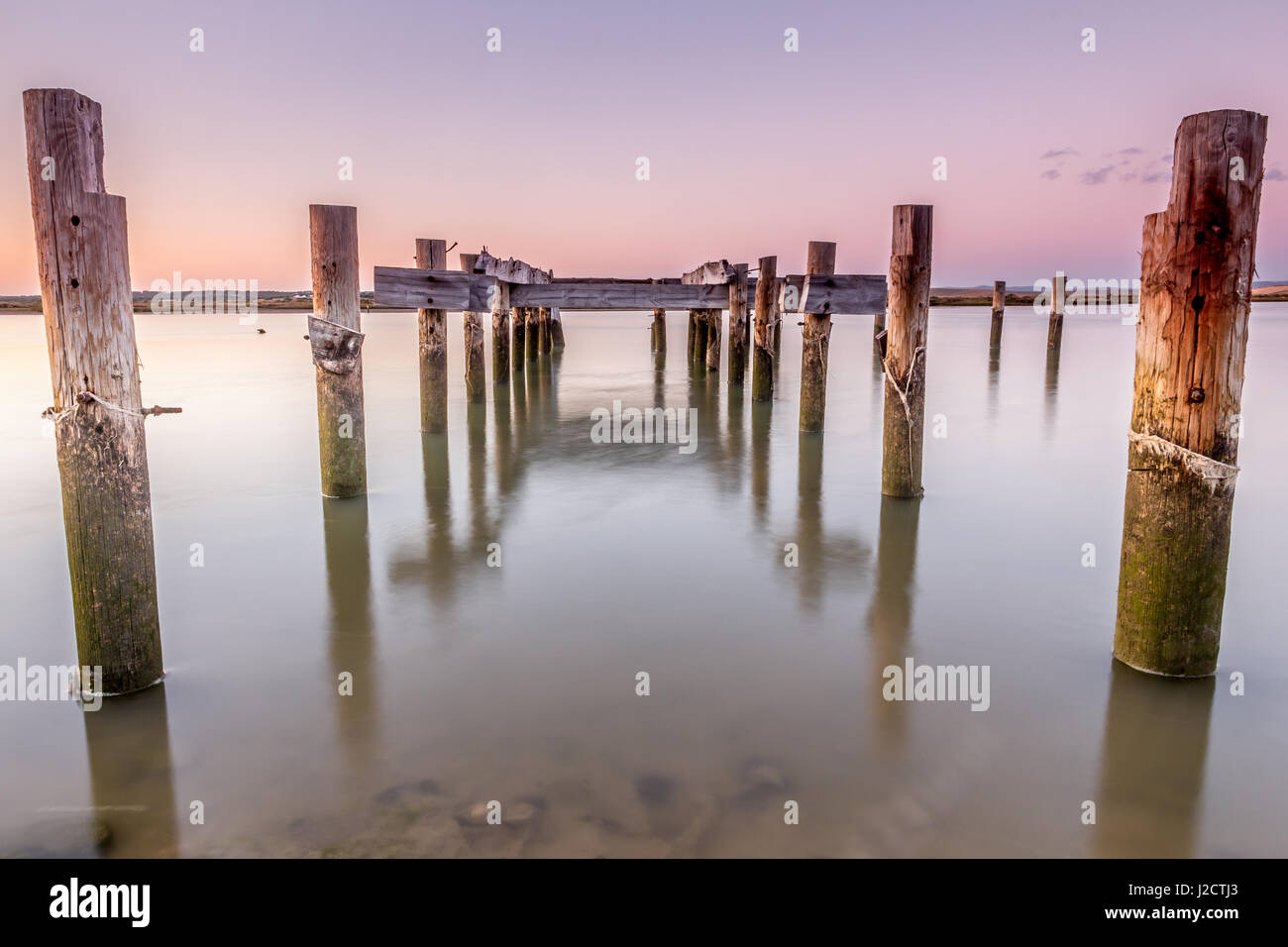 Fotografie con lunghi tempi di esposizione. In prossimità della foce del fiume Barbate. Il vecchio molo in legno al tramonto rotto in Barbate fiume, Cadiz, Spagna Foto Stock