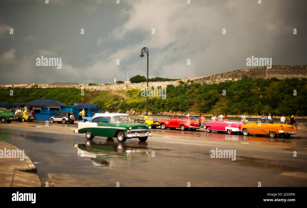 Cuba, La Habana, old American Cars driving sul Malecon Foto Stock