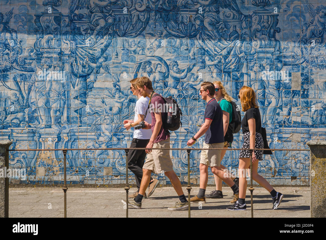 Giovani Portogallo, un gruppo di giovani cammina attraverso un muro nel chiostro della cattedrale se decorato con piastrelle azzurre azulejos, Porto, Portogallo, Foto Stock