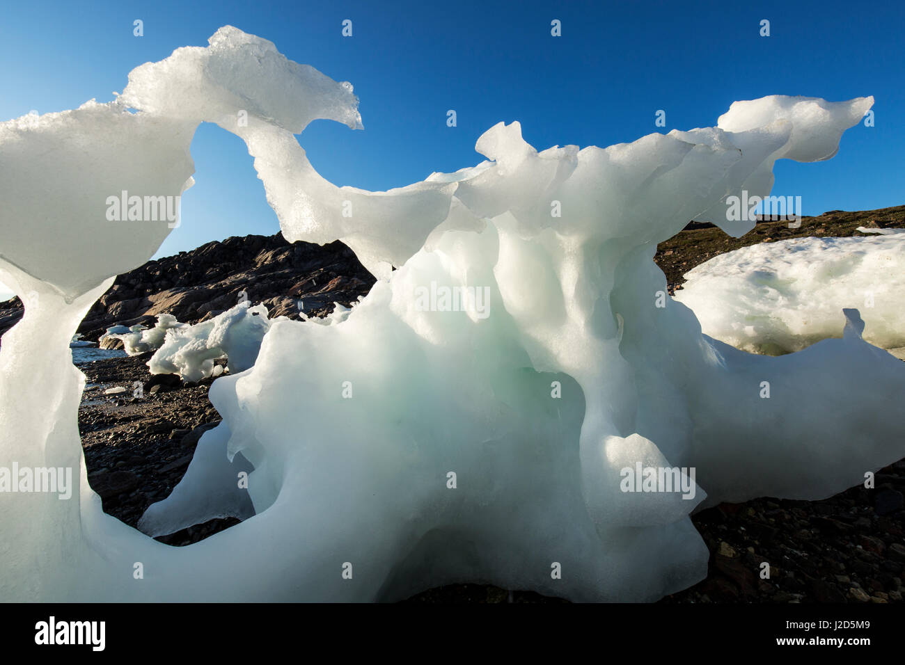 Canada, Nunavut Territorio, impostando il sole di mezzanotte luci iceberg di fusione cordato a bassa marea nel canale di congelati a bordo settentrionale della Baia di Hudson vicino al Circolo Polare Artico Foto Stock