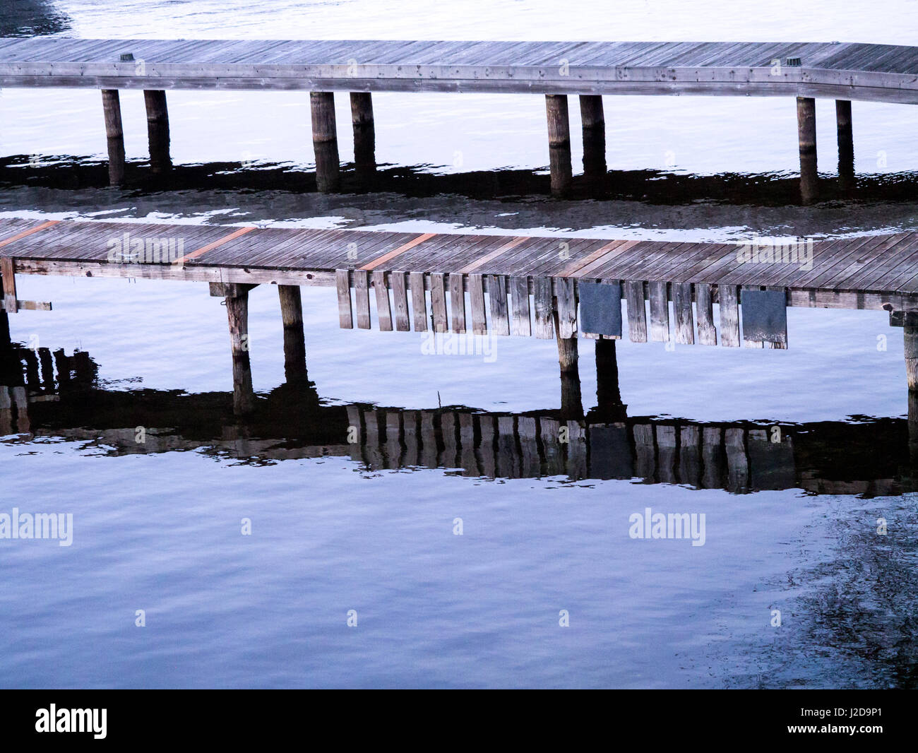 Dock in legno del vecchio tavole con riflessioni, orientamento orizzontale Foto Stock