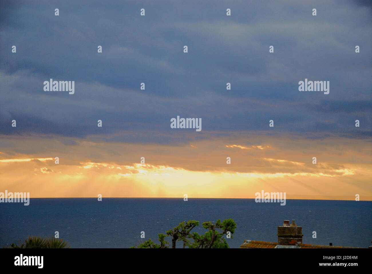 Lyme Bay, Dorset, Regno Unito. 27 apr, 2017. Regno Unito Meteo. Raggi di sole pierce le dense nubi come il sole tramonta sulla Baia di Lyme Credito: stuart fretwell/Alamy Live News Foto Stock