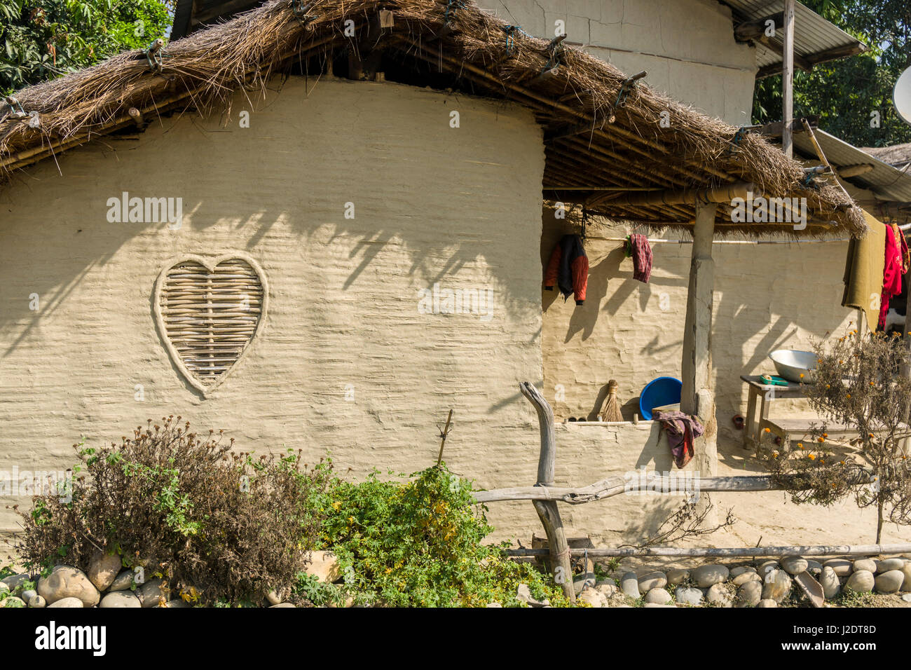 La facciata con una finestra di una tipica casa colonica nel villaggio pandavnagar in Chitwan il parco nazionale Foto Stock