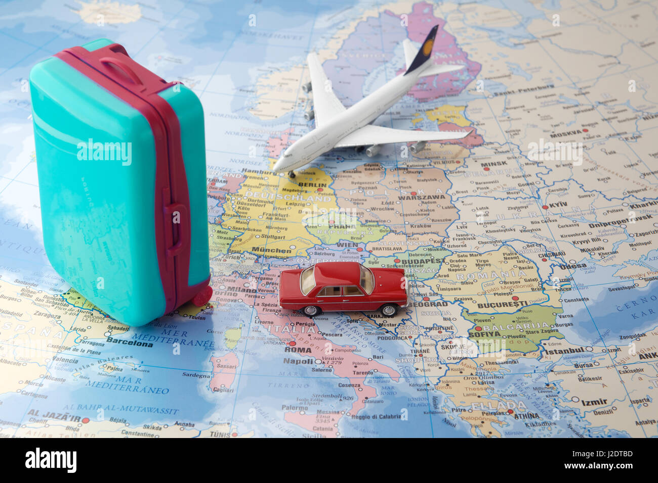Viaggio o viaggiare in aereo concetto. Miniatura aeroplano giocattolo, auto  e valigie sulla mappa Foto stock - Alamy