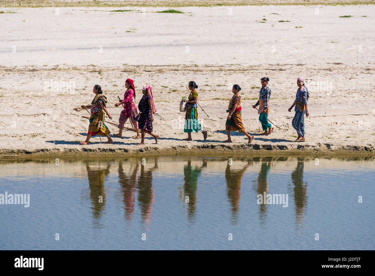 Un gruppo di donne locali dal villaggio pandavnagar sono a piedi lungo il fiume rapti in Chitwan il parco nazionale Foto Stock