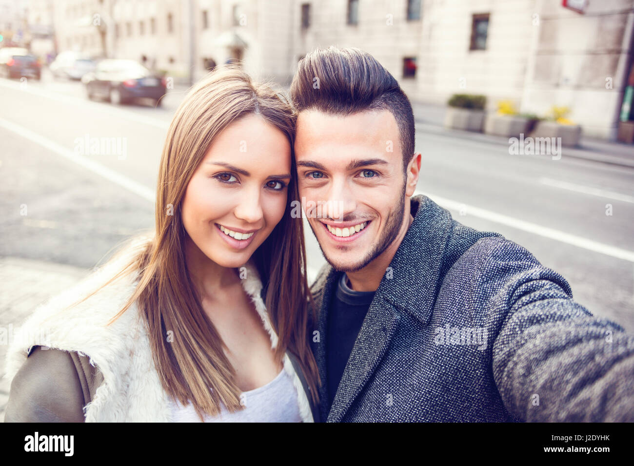 Felice coppia giovane tenendo selfie dal telefono mobile su strada. Bella giovane selfie, amore e il concetto di divertimento. Tonica foto, Close up ritratto. Foto Stock