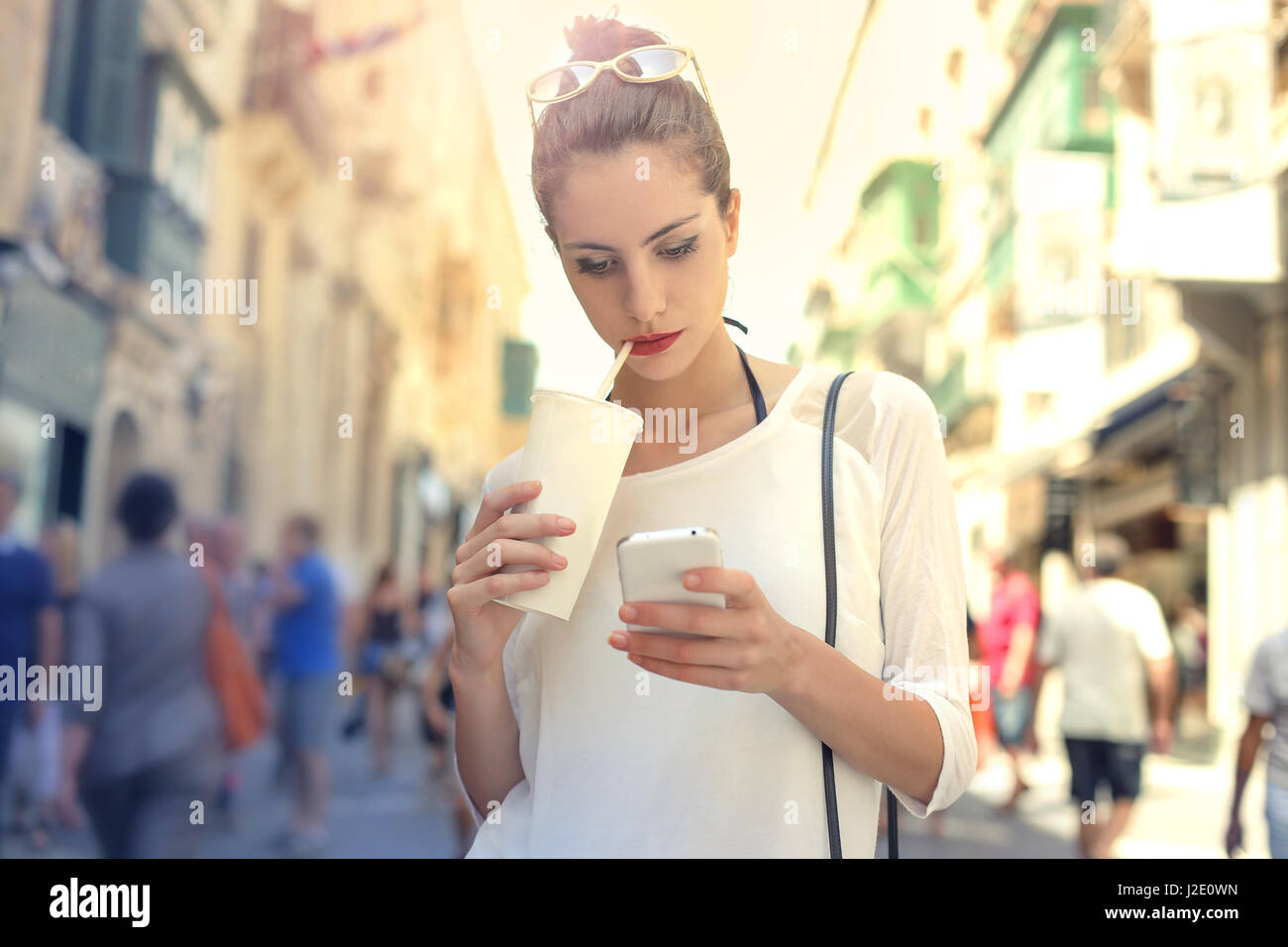 Donna elegante bere dal bicchiere esterno Foto Stock