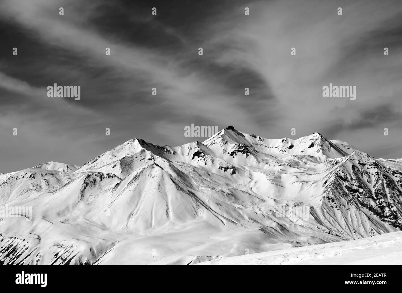 Inverno neve montagne nella giornata di vento. Montagne del Caucaso, Georgia, regione Gudauri. Bianco e nero paesaggio dai toni. Foto Stock