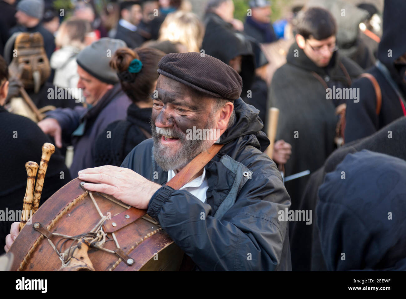 L'Italia, Sardegna, Gavoi. L'uomo coperte di fuliggine di sughero giocando un tamburo, parte di una tradizionale festa pagana. Foto Stock