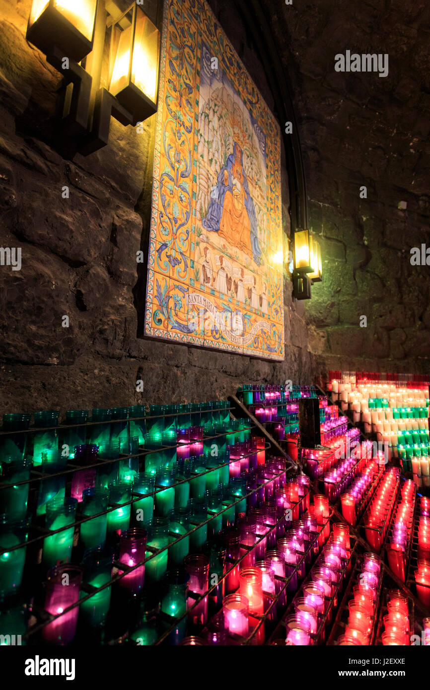Candele accese all'interno di una piccola grotta del monastero Benedettino di Montserrat nella periferia di Barcellona, Spagna Foto Stock