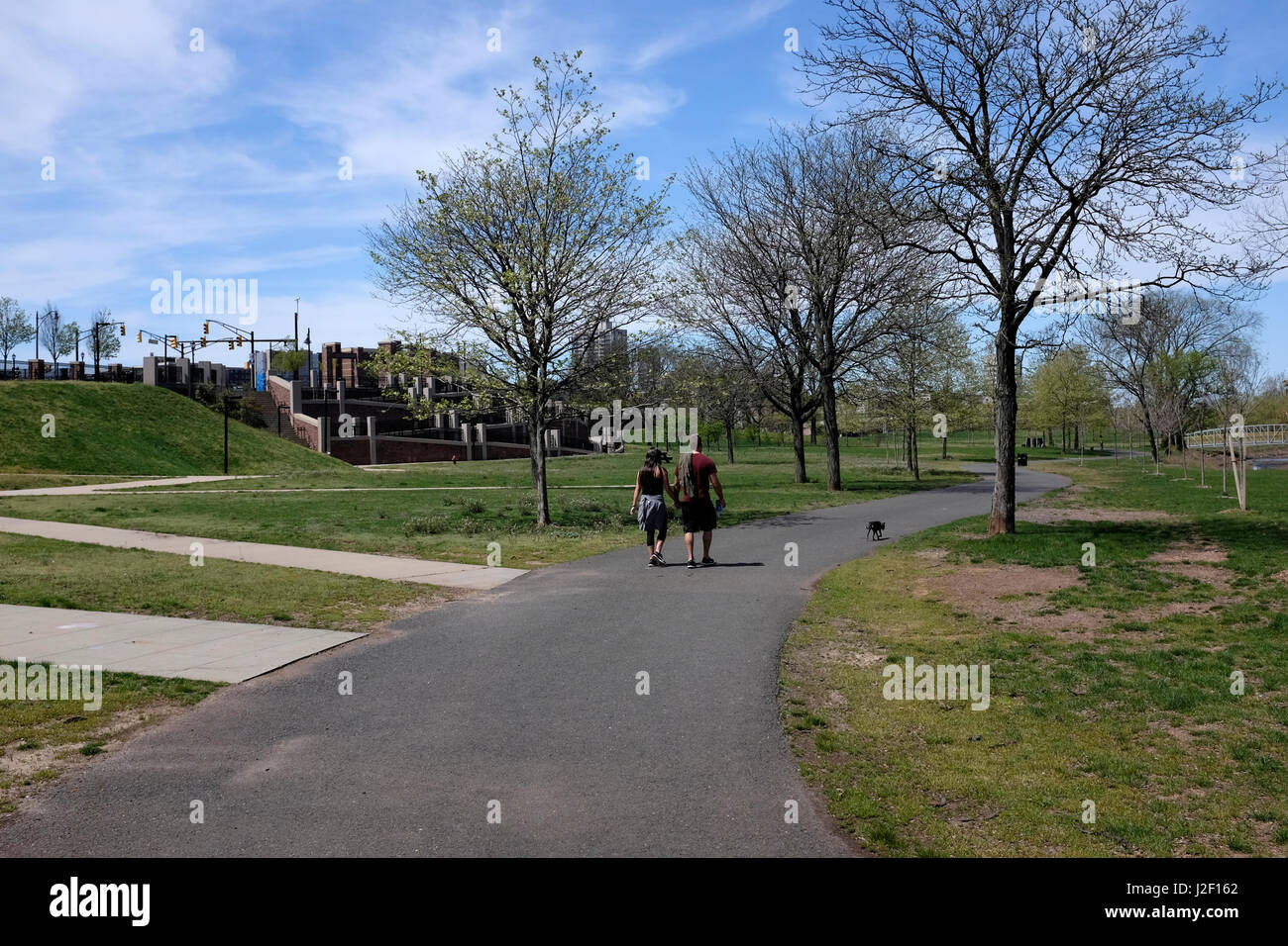 Giovane a piedi il loro cane in Boyd Park, New Brunswick, NJ Foto Stock